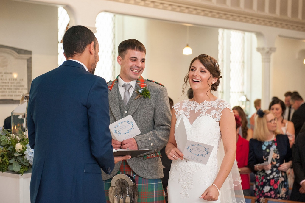 Bride and groom laughing during their church wedding ceremony, captured by a documentary wedding photographer